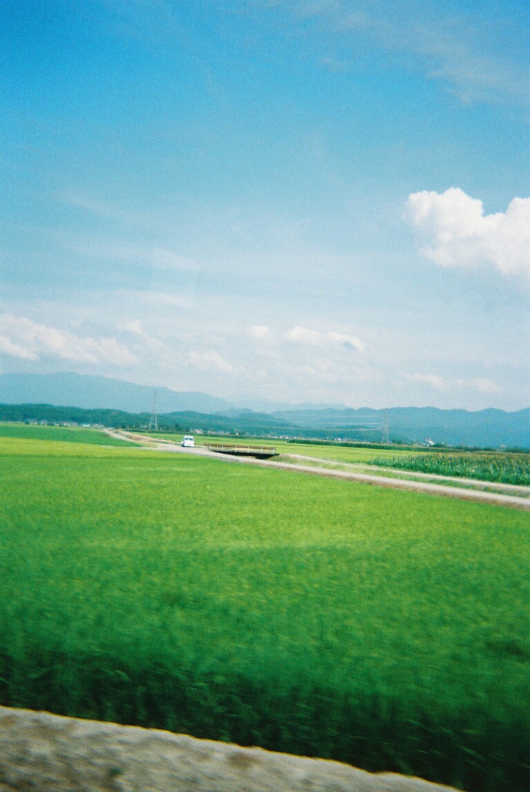 バスの中から撮った一枚。田んぼにポツンと置かれた軽トラック。こう見るとなんだかジオラマのよう。