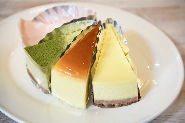 【手づくりチーズケーキ工房 ちーず屋】左から順に：ラズベリーベイクドチーズケーキ、抹茶ニューヨークチーズケーキ、スフレチーズケーキ、ニューヨークチーズケーキ。