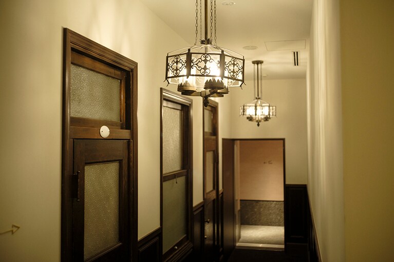 旧小樽商工会議所で使われていた窓や扉を壁に設置した、南館1階の通路。レトロなシャンデリアも可愛い。