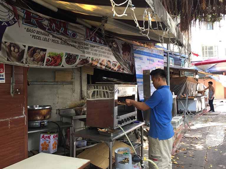 暑い太陽の真下で、サテを焼く様子。