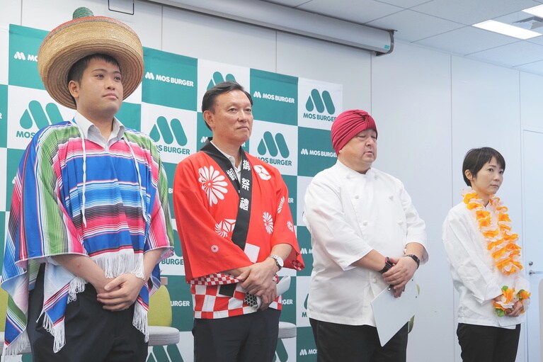 左から「タコスバーガー」担当の渡部さん、「肉盛りバーガー」の永野さん、「モスチキン」の荒木さんに「オレンジ＆マンゴーティー」の堤さん。なぜかコスプレで登場！