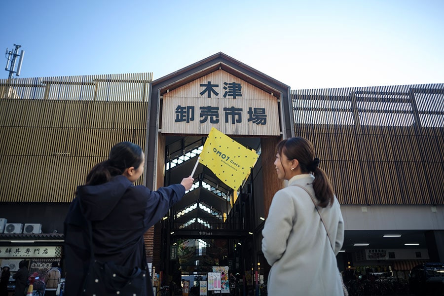 木津市場に到着！　OMOレンジャーが持っている黄色い旗も、篠原さんがデザインしたもの。