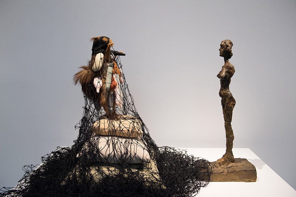 母、妻、メサジェ共通の名の下に、彼女たちの作品を集めた「アネットたちの部屋」より。立像のアネットとメサジェ作《リスのパレード》。全裸の妻と網に覆われたメサジェ自身を対峙させたアイロニー。