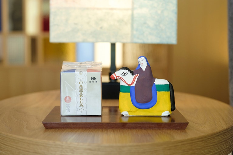 ウェルカムスイーツのカステラは福砂屋とコラボ。右は長崎に伝わる伝統工芸の土人形「古賀人形」。