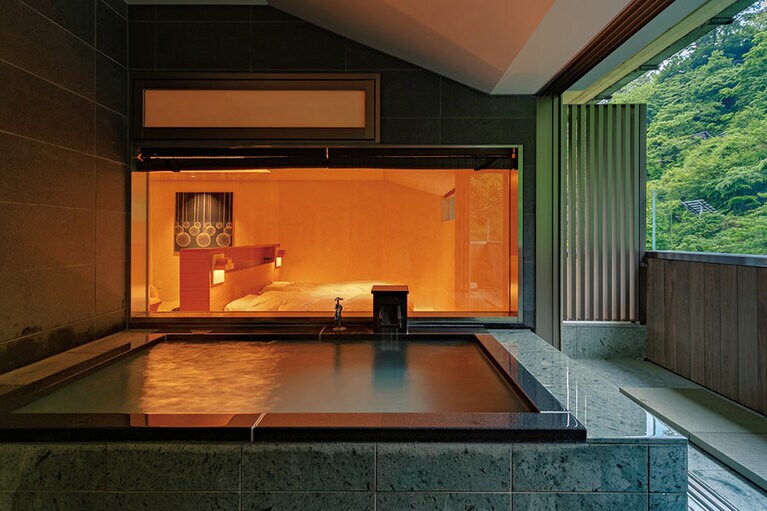 露天風呂付き客室の椿。湯は体が温まる泉質で、目の前の山肌にカモシカや野ウサギが姿を見せることもしばしば。客室の露天風呂もすべて源泉かけ流し。