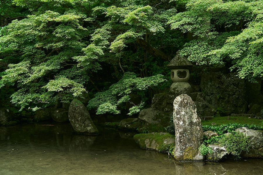 鶴や亀に見立てた石組みを配した池泉回遊式庭園。