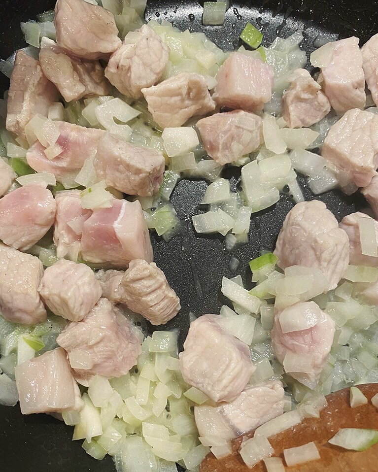 【ごろっと豚肉とマッシュルームのパセリバター炊き込みごはん】(4) フライパンバターを入れて火を付けて溶かし、豚肉と玉ねぎ、にんにくを加えたら弱めの中火でじっくり炒める。