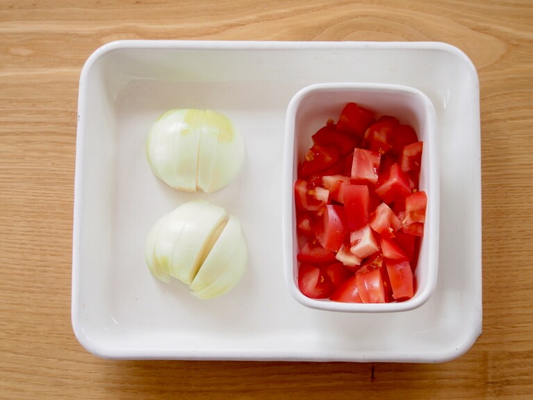 玉ねぎは大きめのくし切り、トマトはヘタを取り除き、角切りにする。