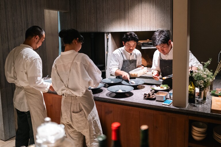 ダイニングキッチンのような空間で料理を仕上げるシェフのみなさん。（撮影：石川博也）