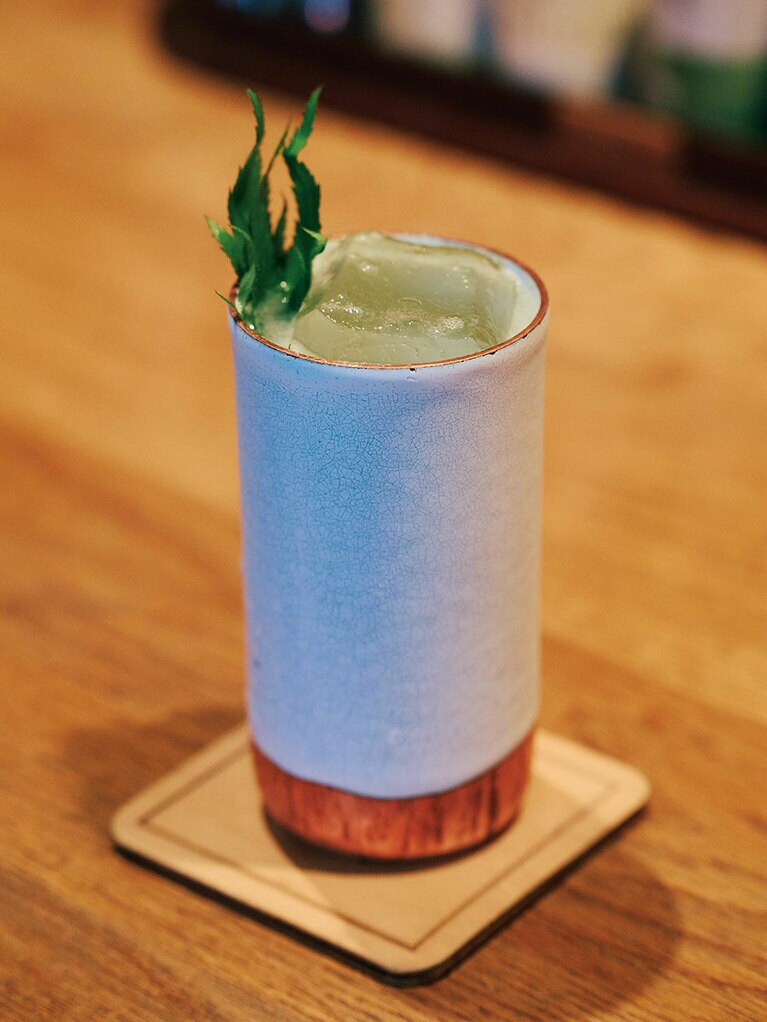 クラフトジンをベースにライムや自家製生姜ビールなどを加えた「One Fine Spring Day」W22,000。高麗人参のフレッシュな葉を添えて。