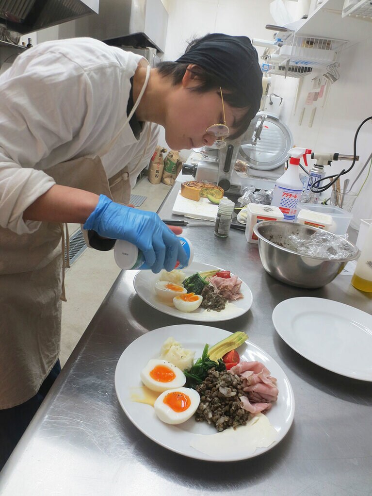 ワンプレートモーニングを仕上げる村西さん。