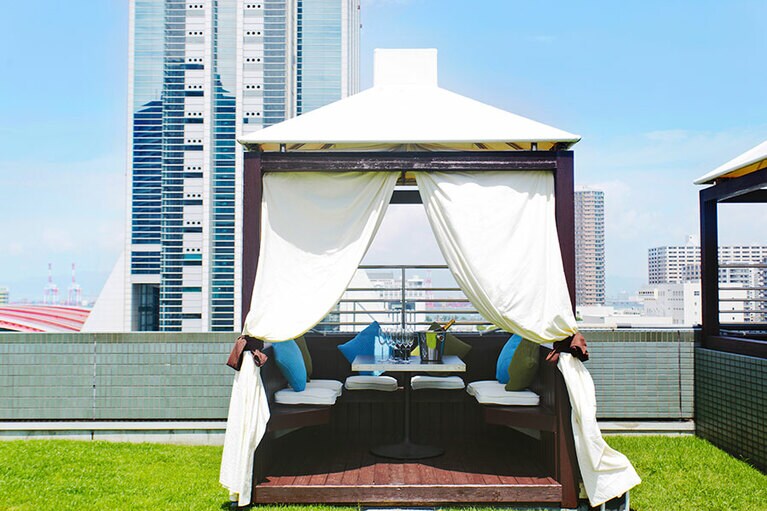 「BBQ フィエスタ ラティーナ」のオプション半個室シート「ガゼボ」1区画（2～4名用）6,000円。飲食代別・赤ワイン1本とフルーツプレート付き。