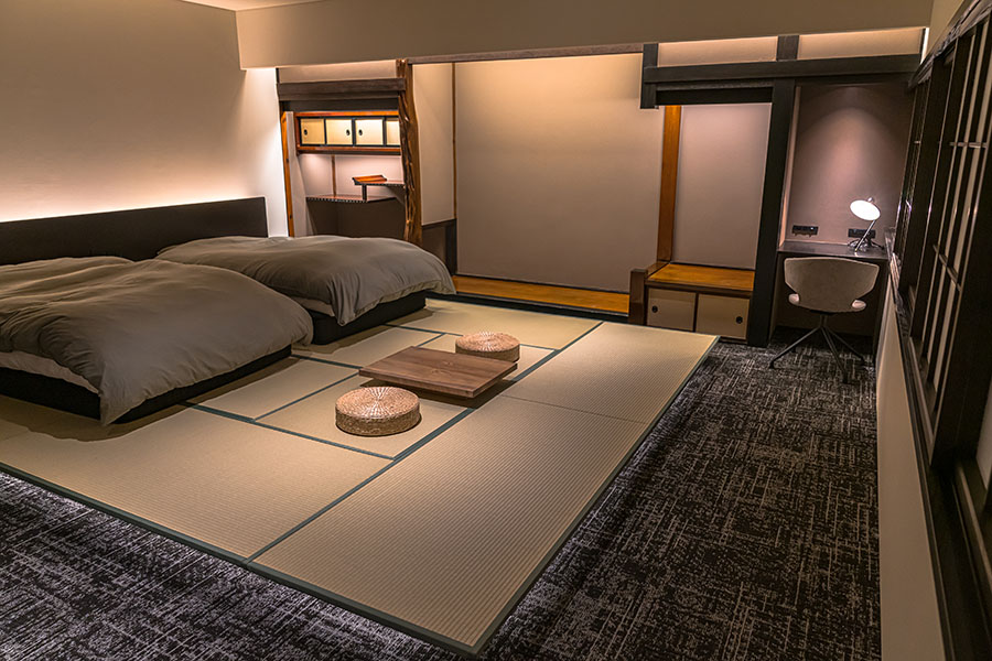 15畳の和モダンなツインベッドルーム「榧（かや）の間」は、隈研吾建築都市設計事務所のデザイナーが手がけたもの。🄫ご縁の宿 伊藤屋