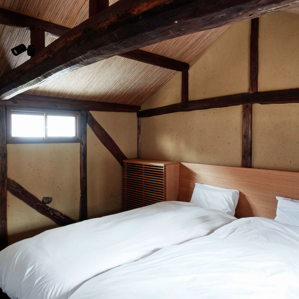 低い梁とヨシの天井のベッドルームは2階に。