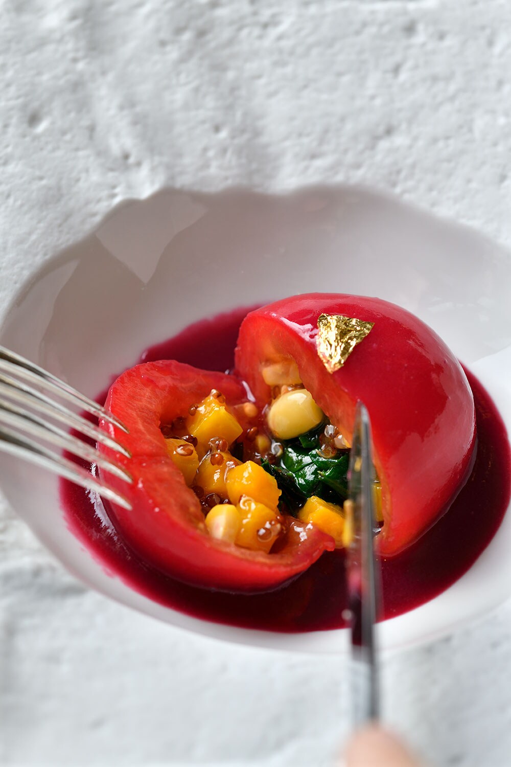 スーパーフードのキヌアを詰めて蒸した日本産トマト、ムラサキイモのペーストを添えて。