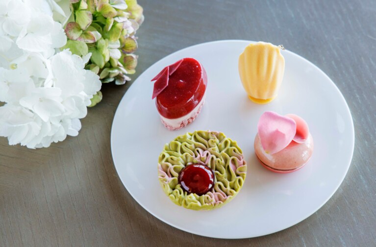 スイーツプレートのイメージ。右上から順に、「ハチミツムース、クレームシトロン、ダクワーズノワゼット」「桃とバニラのヴァバロワ、桃のコンフィチュール」「ルバーブとラズベリー、ピスタチオのタルト」「苺とルバーブのコンポートジュレ、アールグレイクレムー、苺クランチ」。