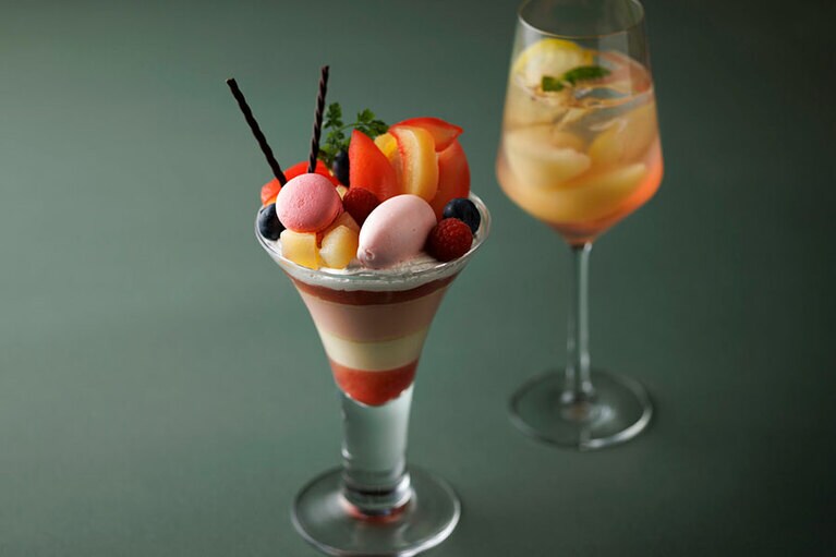 「桃のパフェ」3,700円。「ピーチソーダ」（写真奥、単品 2,200円）とのセットは5,400円。コーヒーまたは紅茶とのセットは5,100円。1日10食限定、予約不可。