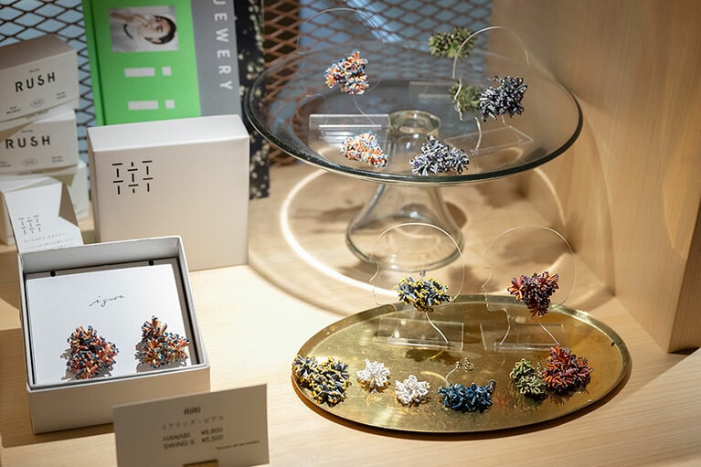 フロント横の壁に飾られているクリスマスツリーをはじめ、空間デザインを手掛けている「itiiti」。代表的なプロダクトの素材には、出身地である熊本県八代地方の井草の端材を使用。アクセサリーやオブジェは、井草とはわからないほど色鮮やかで軽やか。