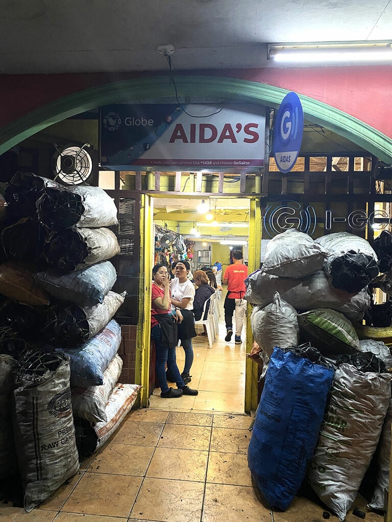 お店の前には鶏を焼くための炭がうず高く積まれていた。