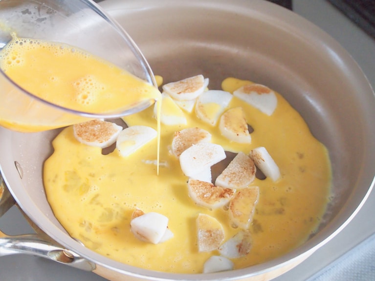 長芋に焼き色がついてきたら、卵を割ってよく混ぜる。フライパンの中に流し入れ、優しく混ぜる。