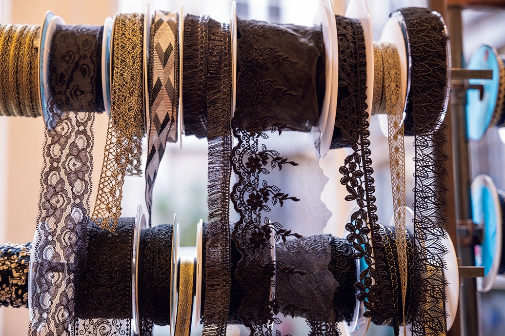 リザ氏の確かな目で選び抜かれたリボンが壁一面に並ぶ。職人が作るレースや絹のリボンは触れるだけで質の良さが伝わってくる。