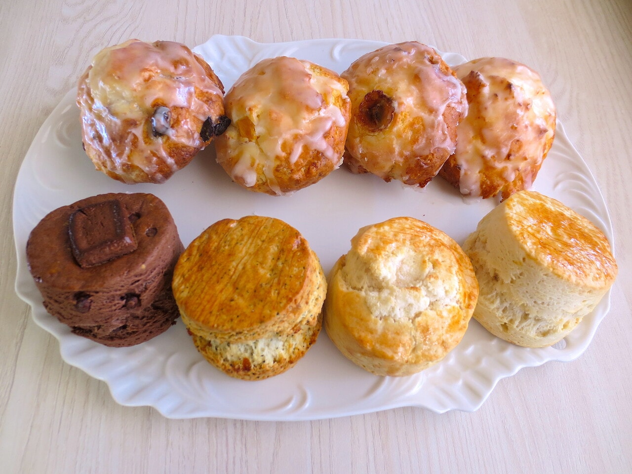 取材時のスコーン全種類。手前／左から「ダブルチョコ」352円、「アールグレイオレンジ」330円、「リッチバターソルト」330円、「プレーン」297円。奥はハワイアンスコーン／左から「ラムレーズン」385円、「マンゴー」385円、「バナナ」385円、「プレーン」352円。（テイクアウトは別価格）
