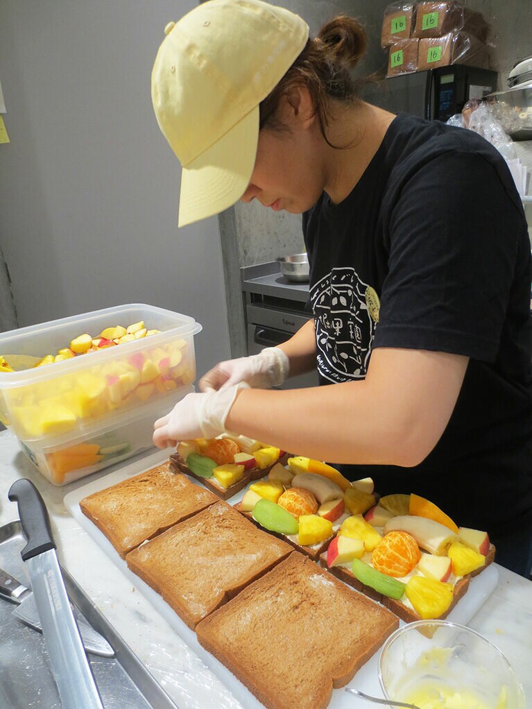 フルーツサンドを作る様子。黒糖食パンに大きくカットしたフルーツをたっぷり並べて。