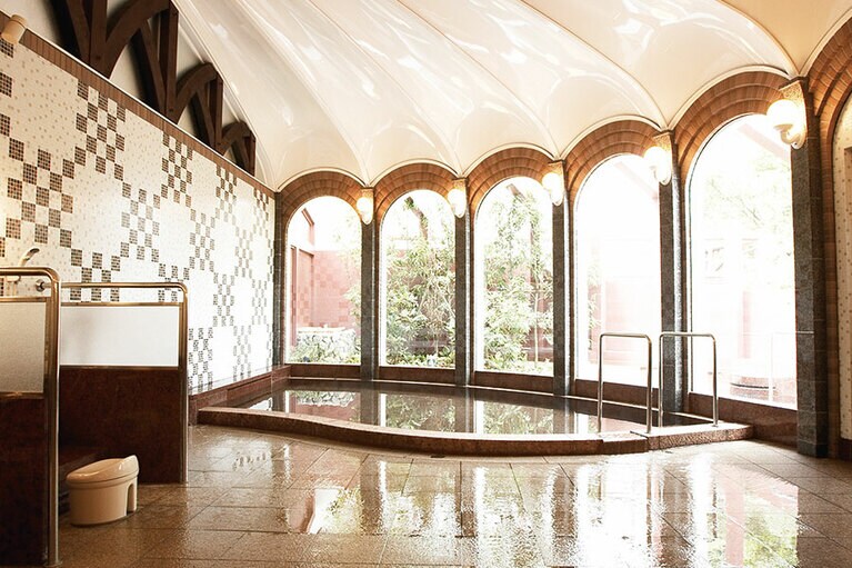 アーチの窓とアール・デコ装飾も味わい深い。湯は自然湧出の自噴泉で源泉かけ流し。