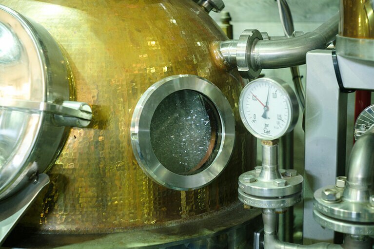 蒸溜機の窓から原酒が沸騰しているのが見える。