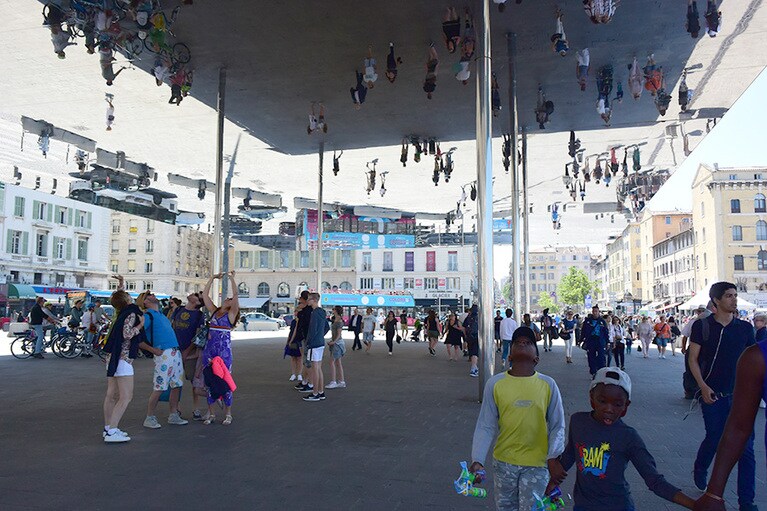 旧港の魚売りスタンドに隣接した、建築家ノーマン・フォスターによるアートな屋根。天井の鏡に、天地逆さな風景が映っています。