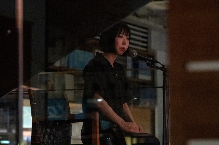 階段の踊り場で話す、深津さくらさん。