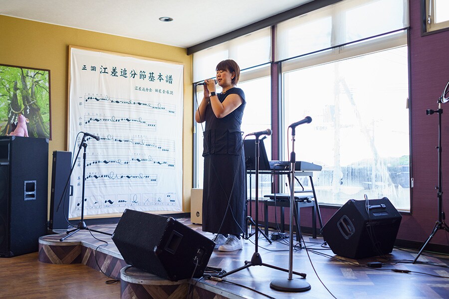 「Café香澄」で江差追分を歌う木村さん。壁には譜面が。