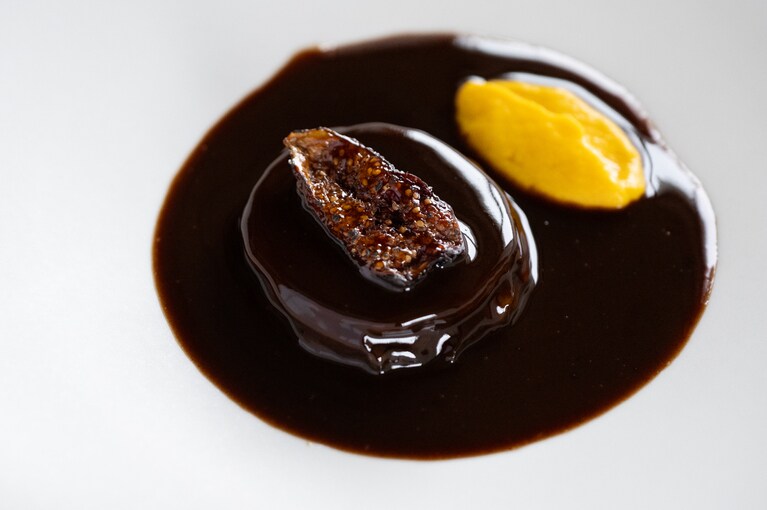 8品目は多彩なジビエを堪能できる「真鴨のロワイヤル」。佐渡産のビオレ・ソリエスをセミドライにし、キャラメリゼしたものをお肉の上に。黄色の彩りが映えるペーストの正体は、秋とは比べものにならない甘さの雪下にんじんです。