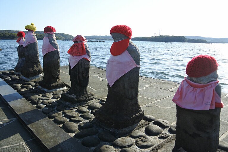 おなかのところの穴にお供えものをする、はらほげ地蔵。