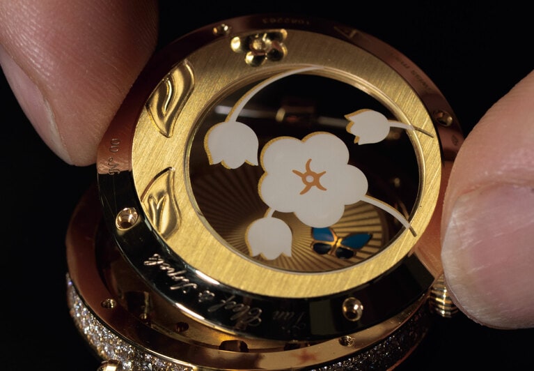 ケースバックのゴールドパーツには繊細な葉のエングレービング。サファイアガラスにはエナメル デカールと呼ばれる伝統的な装飾技法でフローラルモチーフが描かれている。