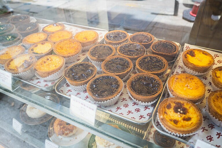 店先のショーケースに並ぶエッグタルトなどのスイーツ。