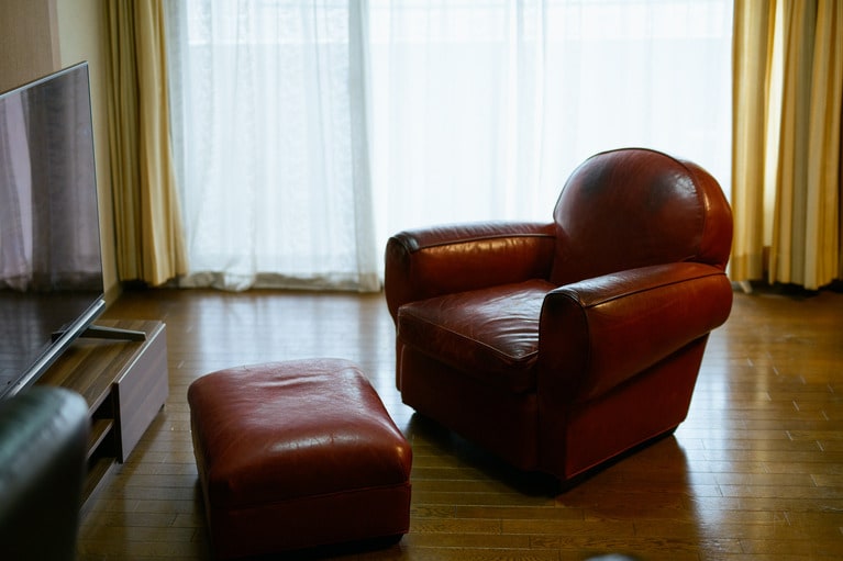 ナンシーさんがテレビを観るときに愛用していた革張りのソファ。さっきまで座っていたような佇まい。