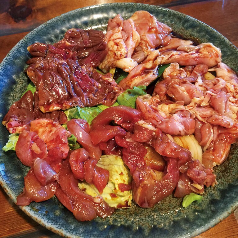 もうもう煙を浴びながら鳥を焼く。