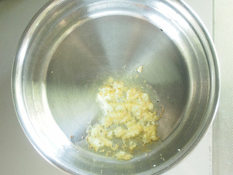 (2) 鍋に菜種油、にんにく、生姜を入れて弱火で加熱します。