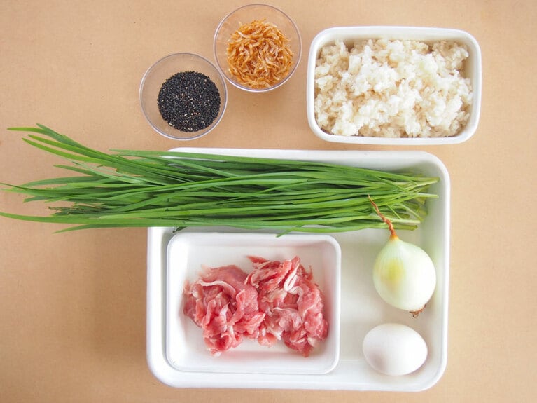 ご飯：2人前／ニラ：1束／豚細切れ肉：100g／玉ねぎ：小1個／卵：1個／干しエビ：大さじ1／黒炒りごま：大さじ1／醤油：小さじ1／みりん：小さじ2／塩：適量／ごま油：適量。