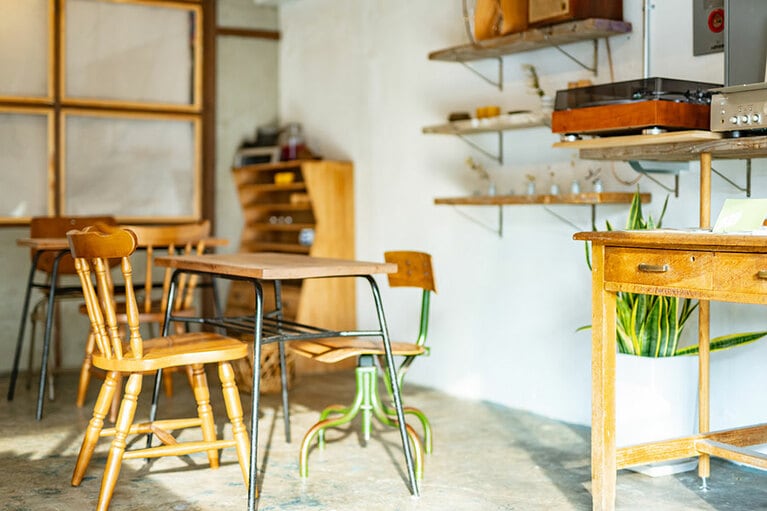 【日暮らしサンドウィッチ】コンクリート打ちっ放しの床や壁に木の温もりが感じられるテーブルや椅子の店内で、コーヒーと一緒にイートインも可能。