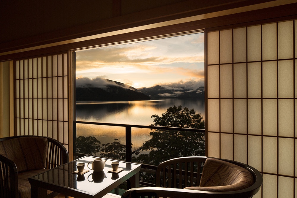 中禅寺湖側の客室から望む、冬景色。奥日光の夕焼けは1年を通して見られる絶景だが、正面に見える日光連山に雪が積もり、夕陽と雪のコントラストがより鮮やかになるのは、冬の時期だけ。
