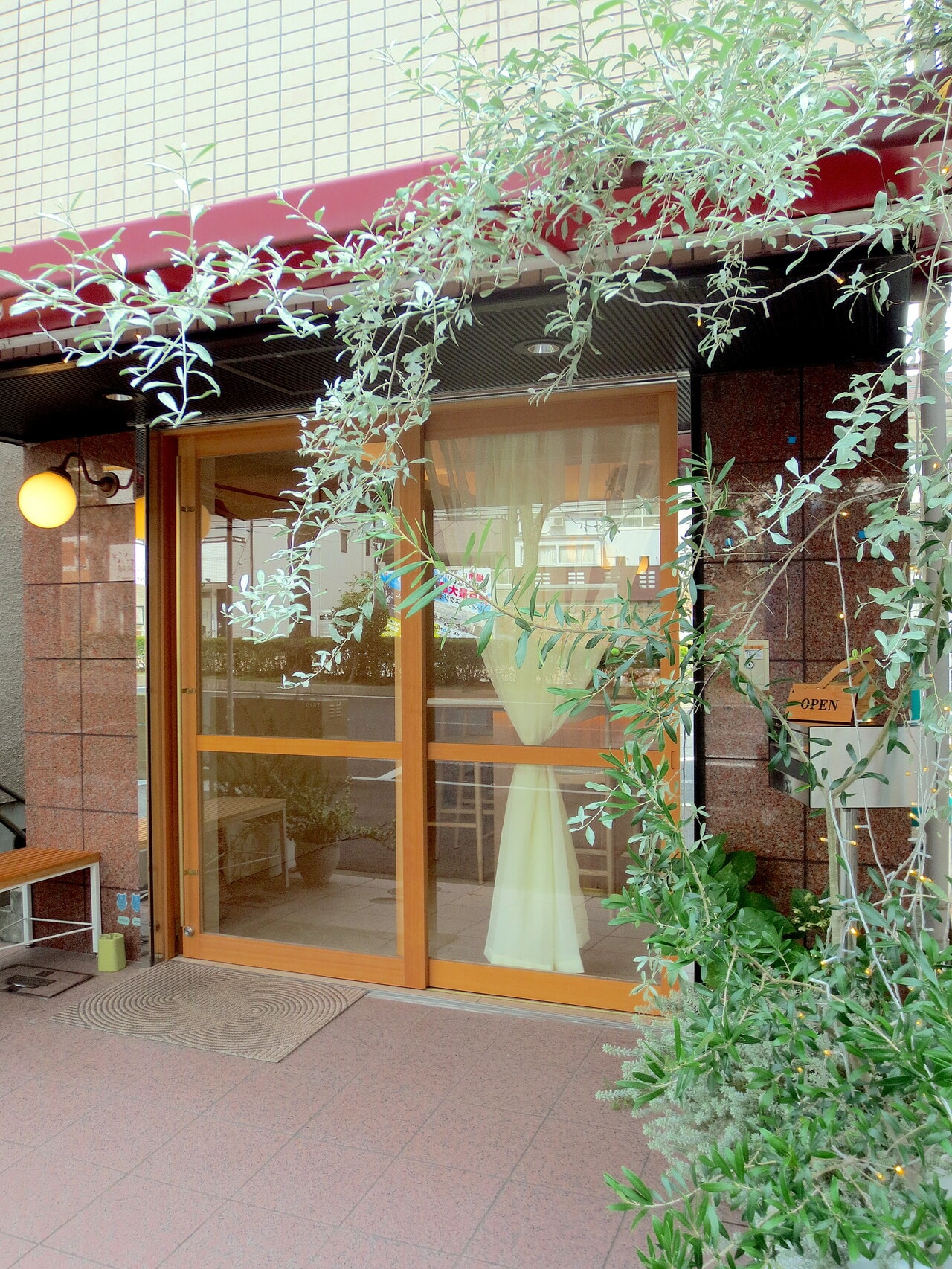 外観。オリーブの木と赤いテントが目印。