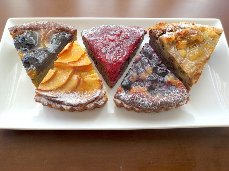 タルトいろいろ。左より「プルーン×ピスタチオ×ショコラ」520円、「りんご」500円、「フランボワーズ×ショコラ」520円、「ブルーベリー×カシス」480円、「バナナ×プラリネ×ショコラ」520円。