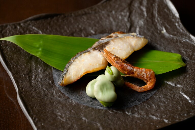 加藤酒造の酒粕で漬けたサワラ焼きは皮までおいしい。そら豆と乾燥させた佐渡産甘エビを添えて。