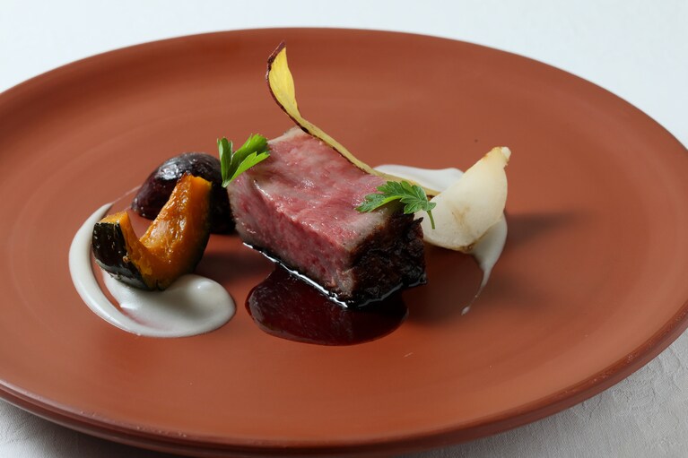 メインのお肉料理、新潟和牛のサーロインのお皿は佐渡ならではの焼物、無名異焼を使用している。