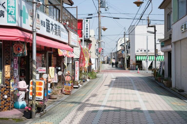 アオイ通り商店街の道路は、枕木を横の線、レールを縦の線と線路を模したカラー塗装が施され、福知山が「鉄道の街」だと感じさせてくれる。