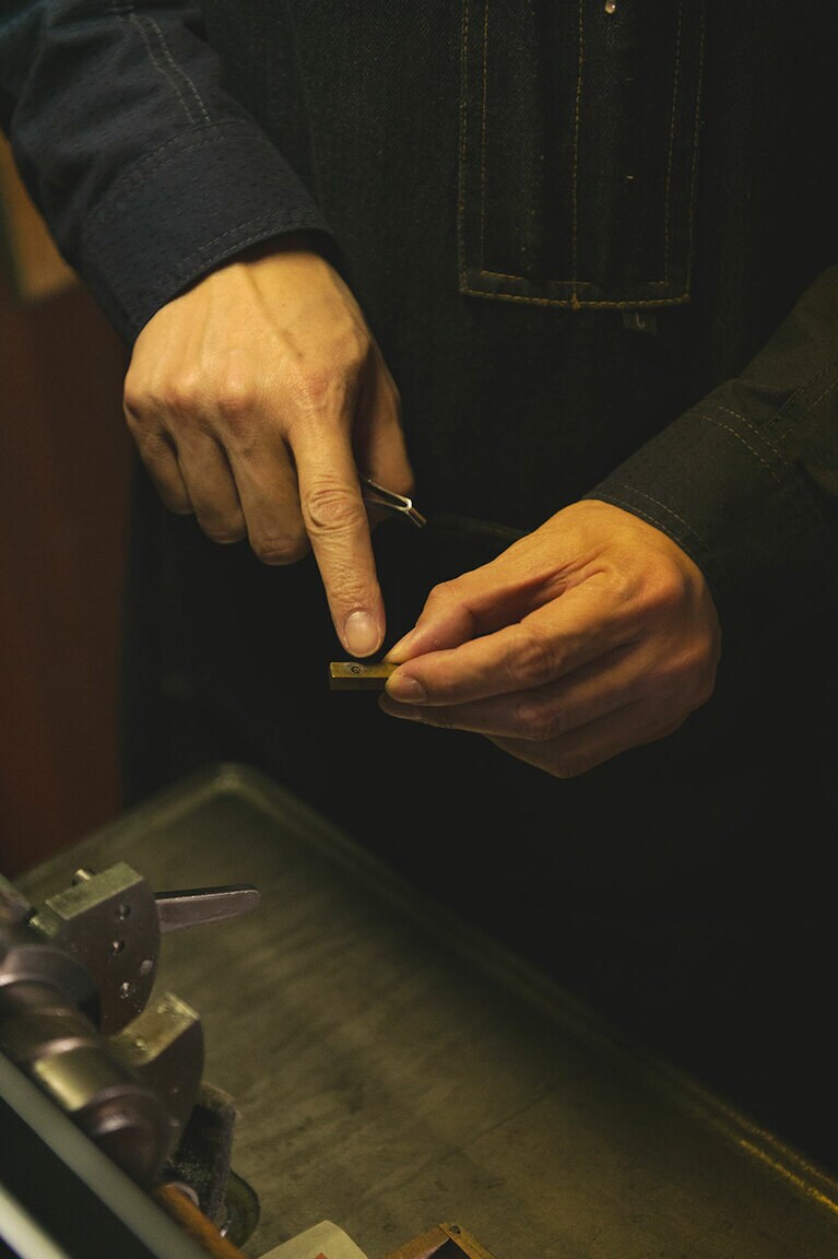 金属活字の説明をする佐々木さん。