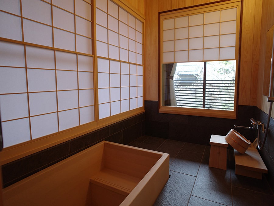 新館の和室の檜の内風呂。障子を模したシェードが、柔らかな光の中での朝風呂を演出してくれる。2階の和室は桜のシーズンには花見風呂になるという。