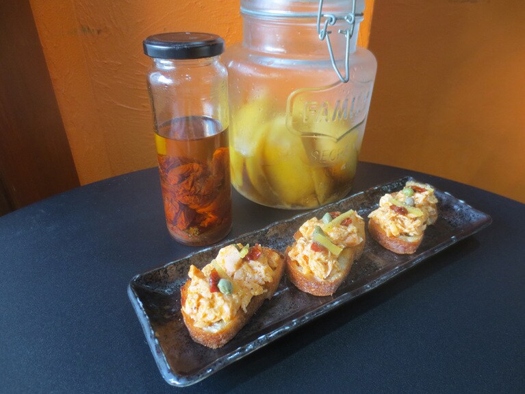 立ち飲みバルのタパスメニュー「サーモンのブルスケッタ」350円には、自家製のサンドライトマトや塩レモンを使用。